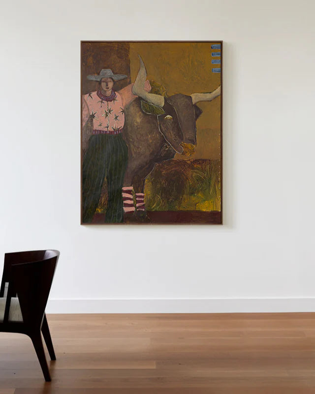 Painting of a person with a longhorn bull on a white wall above a wooden floor.
