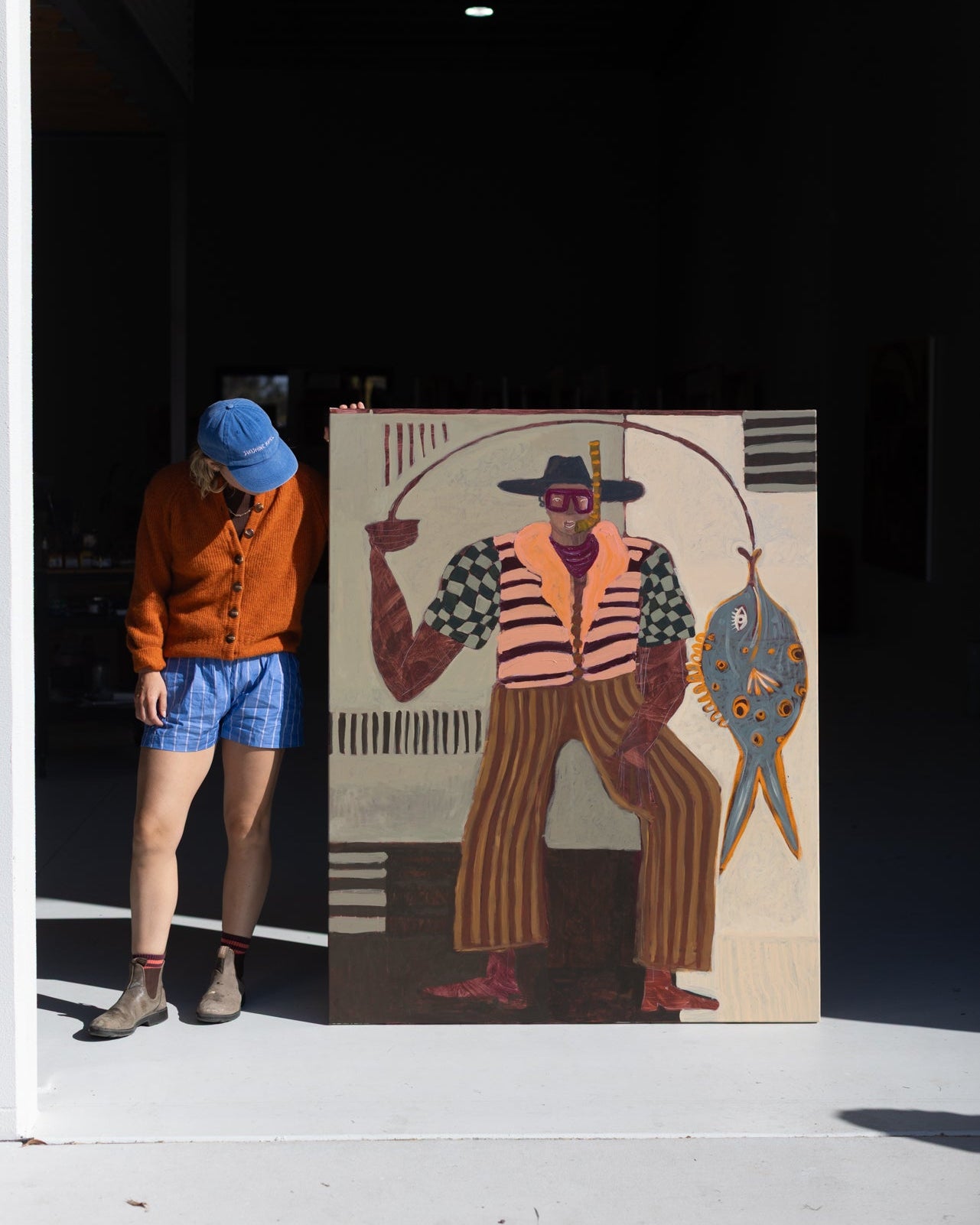 Original canvas painting of a fisherman with a fish. Acrylic paint with earthy tones and pops of bright colour. 