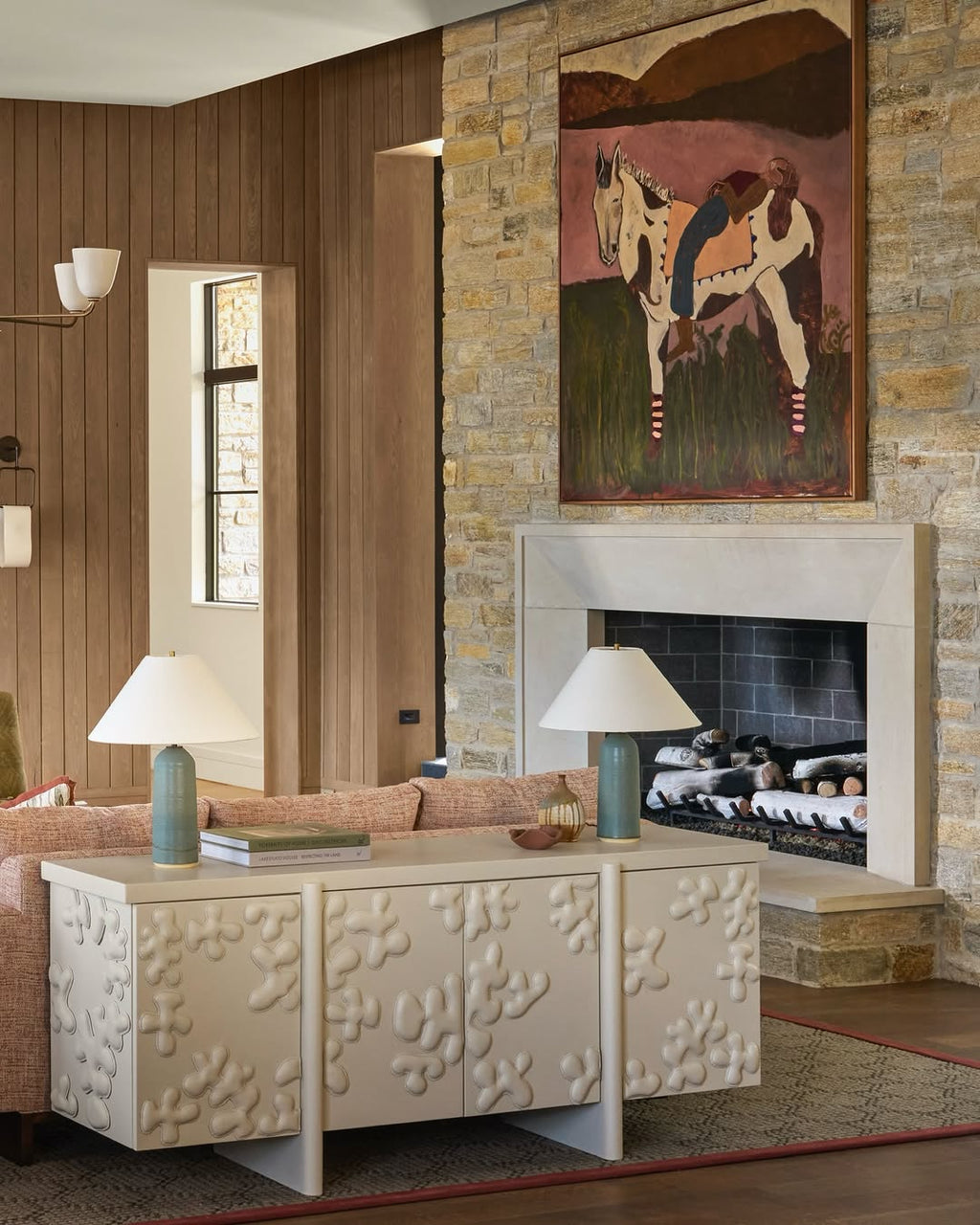 Living room with textured wall, fireplace, and original artwork by Kate Florence.