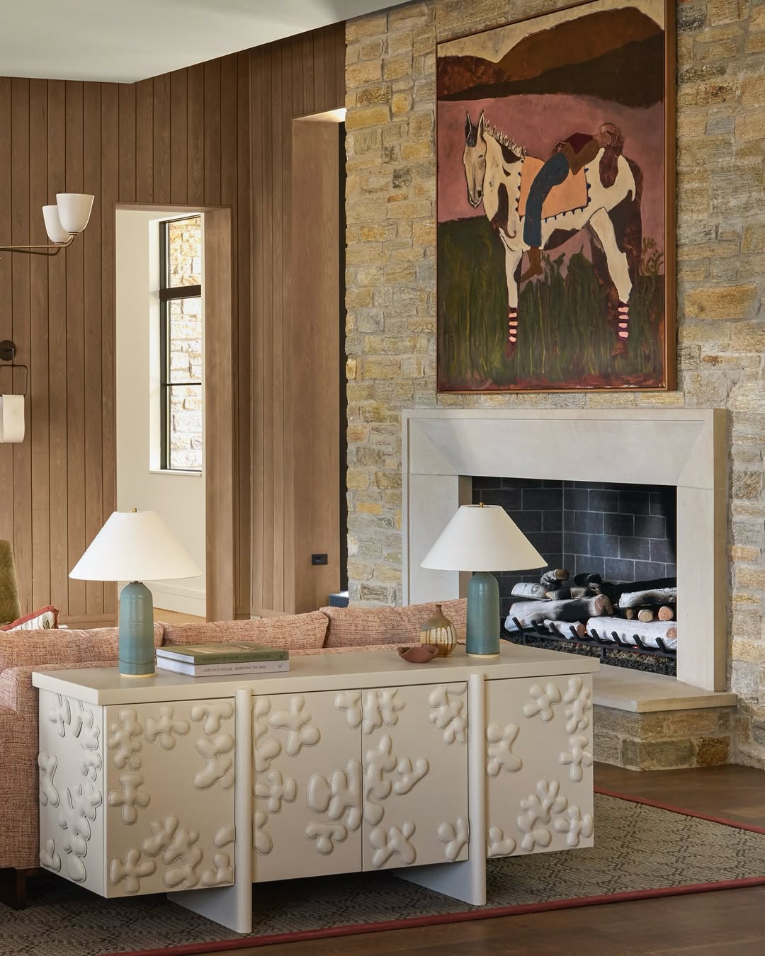 Living room with textured wall, fireplace, and original artwork by Kate Florence.