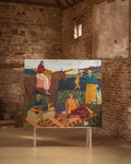 A large colorful painting depicting figures, animals, and landscapes, displayed on a white stand inside a rustic stone and brick gallery room.